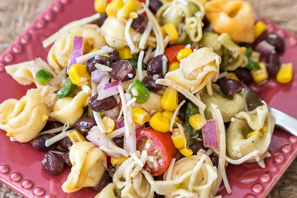A serving of summer tortellini salad with corn salsa on a plate.